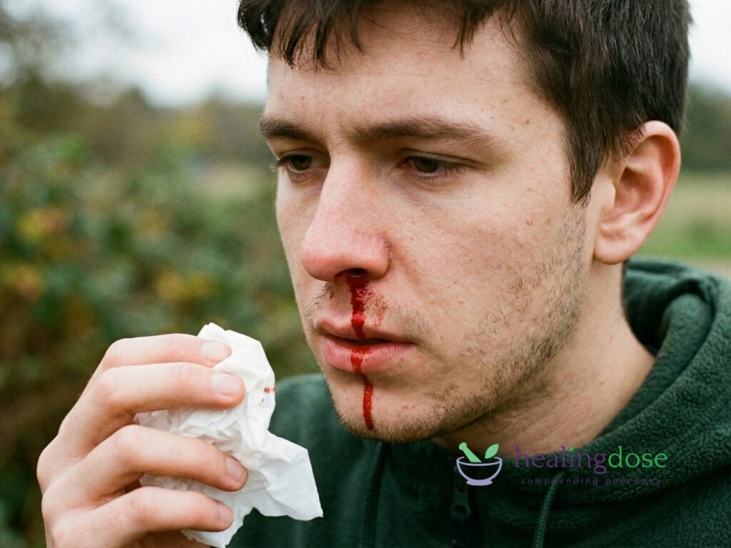 Man Experiencing Nosebleed Holding Tissue Outdoors